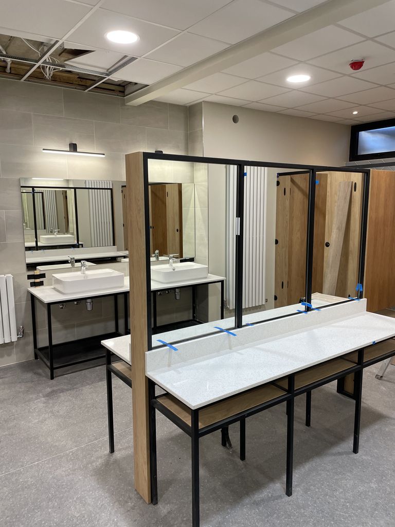 Epsom glass and glazing - an image of back to back bespoke mirrors in a cloakroom produced and installed by Hamilton Glass Products Ltd